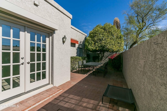 view of patio with french doors, a fenced backyard, and outdoor dining area