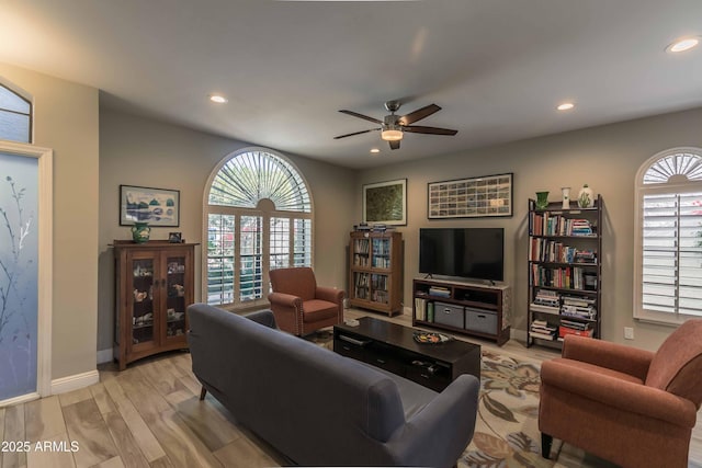 living room with baseboards, ceiling fan, light wood-type flooring, and recessed lighting