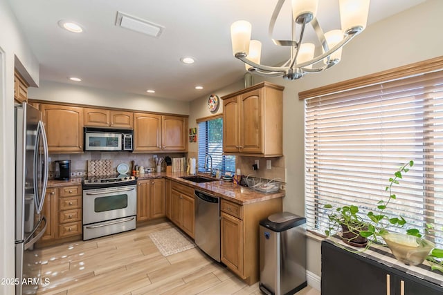 kitchen featuring visible vents, appliances with stainless steel finishes, decorative backsplash, and a sink