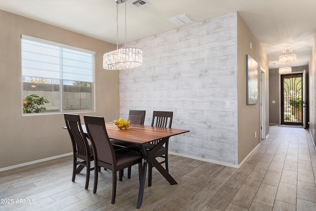 26242 N 122nd Ln, Peoria, AZ 85383 - dining room featuring baseboards, an inviting chandelier, visible vents, an accent wall, and wood tiled floor