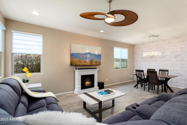 26242 N 122nd Ln, Peoria, AZ 85383 - living room featuring recessed lighting, ceiling fan with notable chandelier, baseboards, and a lit fireplace