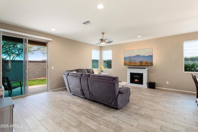 26242 N 122nd Ln, Peoria, AZ 85383 - living room featuring visible vents, a warm lit fireplace, and a healthy amount of sunlight