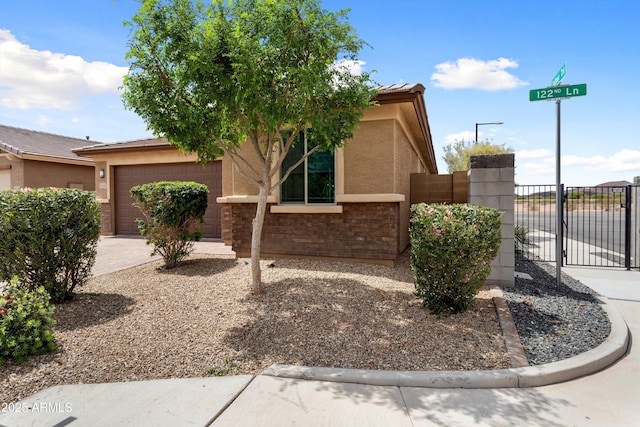 26242 N 122nd Ln, Peoria, AZ 85383 - view of front of house featuring a garage, fence, stucco siding, a gate, and driveway