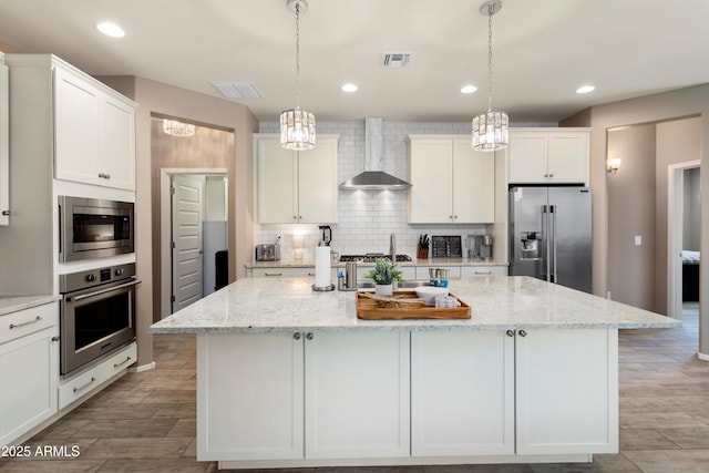 26242 N 122nd Ln, Peoria, AZ 85383 - kitchen with tasteful backsplash, visible vents, wall chimney exhaust hood, appliances with stainless steel finishes, and a chandelier
