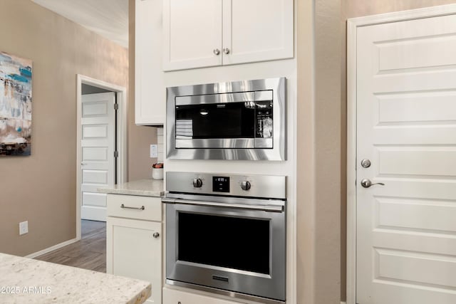 26242 N 122nd Ln, Peoria, AZ 85383 - kitchen featuring baseboards, white cabinetry, wood finished floors, stainless steel appliances, and light stone counters