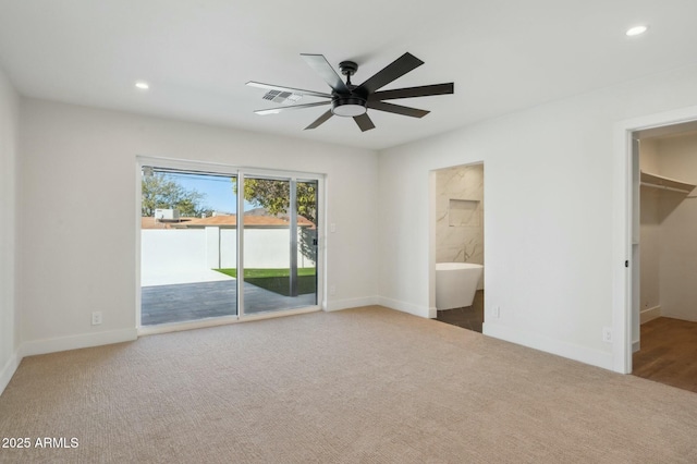 unfurnished bedroom featuring carpet, a spacious closet, access to exterior, ceiling fan, and a closet