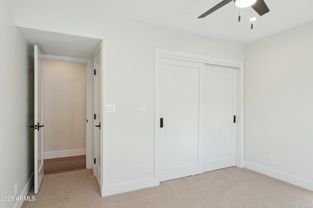 unfurnished bedroom with a closet, light carpet, and ceiling fan