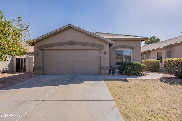 single story home with a tile roof, driveway, an attached garage, and stucco siding