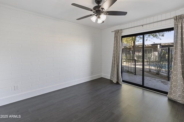 spare room with brick wall, dark hardwood / wood-style floors, and ceiling fan