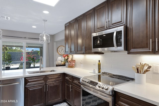 kitchen featuring tasteful backsplash, appliances with stainless steel finishes, sink, dark brown cabinetry, and pendant lighting