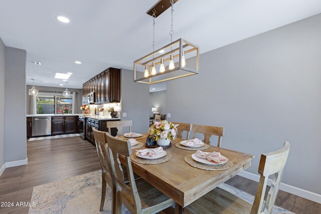 dining area featuring a notable chandelier and dark wood-type flooring