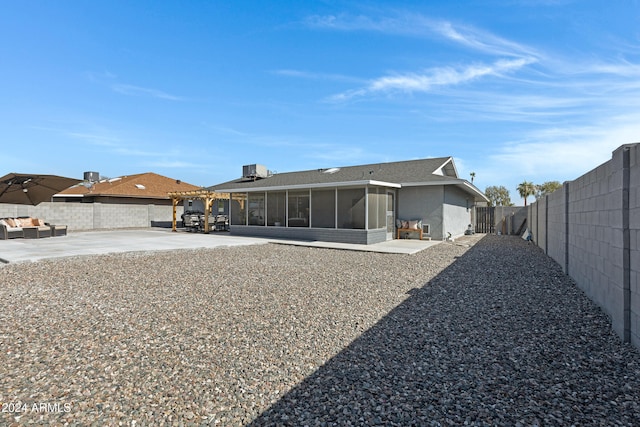 rear view of property featuring a sunroom and a patio area