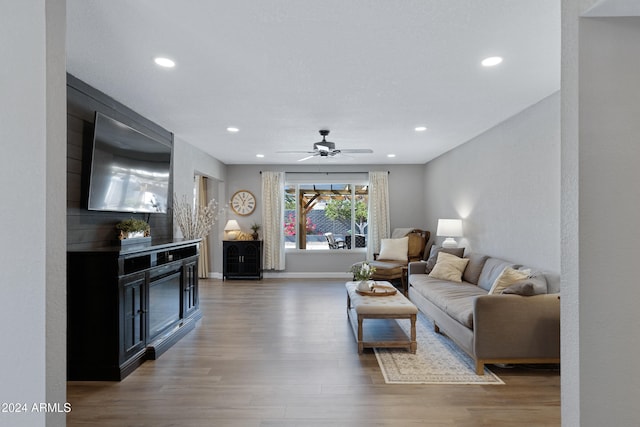 living room with a fireplace, hardwood / wood-style flooring, and ceiling fan