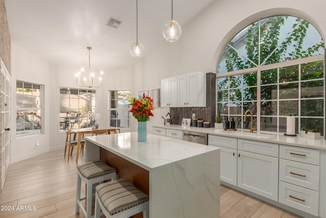 kitchen with a center island, light hardwood / wood-style floors, sink, and light stone counters