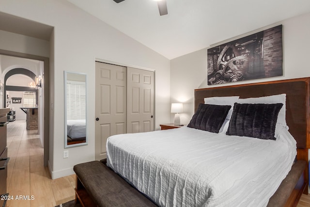 bedroom featuring ceiling fan, wood-type flooring, a closet, and lofted ceiling