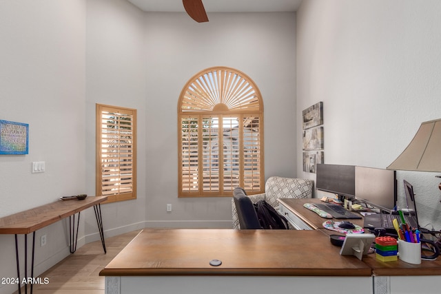 office with light hardwood / wood-style flooring and ceiling fan