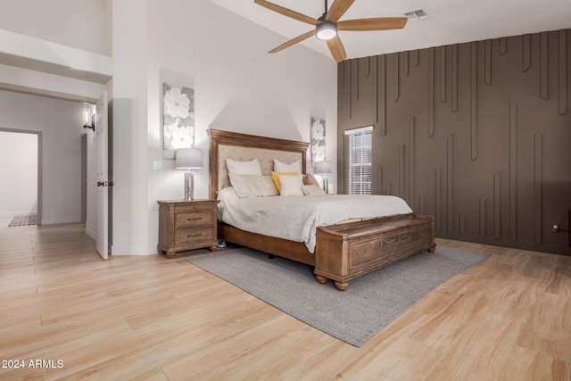 bedroom with ceiling fan, light hardwood / wood-style flooring, and high vaulted ceiling