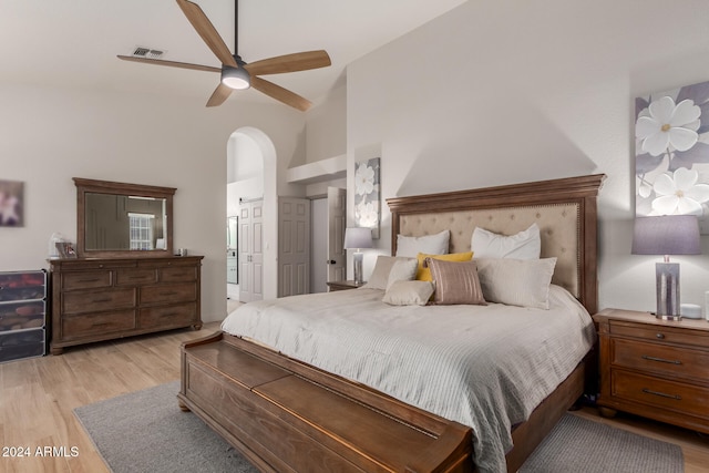 bedroom featuring light hardwood / wood-style floors, ceiling fan, and high vaulted ceiling