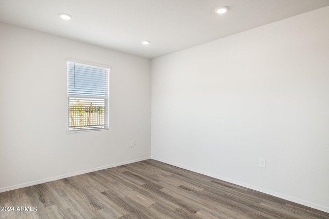 spare room featuring recessed lighting, baseboards, and wood finished floors