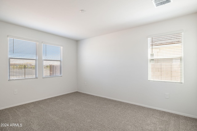 spare room featuring visible vents, baseboards, and carpet floors