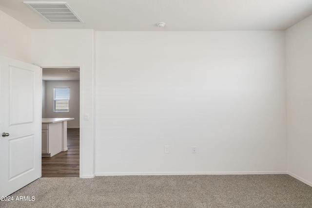 carpeted spare room featuring visible vents and baseboards