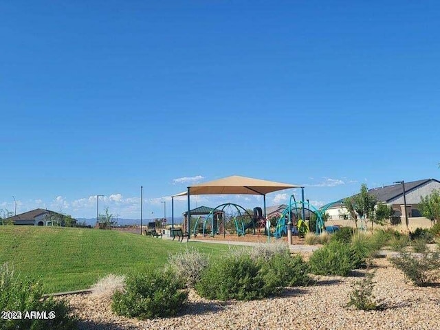 view of property's community with playground community and a yard