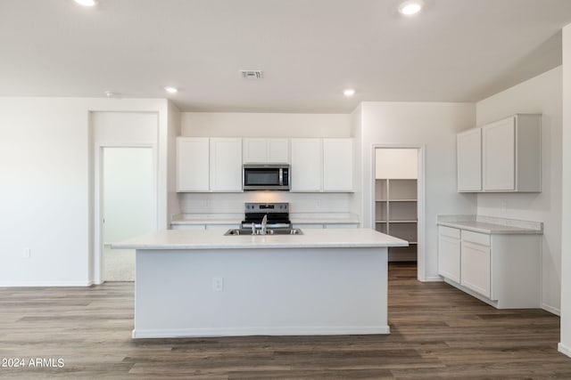 kitchen with visible vents, dark wood-type flooring, light countertops, stainless steel appliances, and a sink