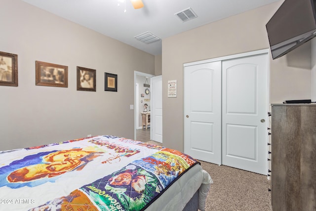 carpeted bedroom with ceiling fan and a closet