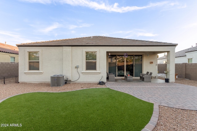 back of house featuring central air condition unit, a patio, and a yard