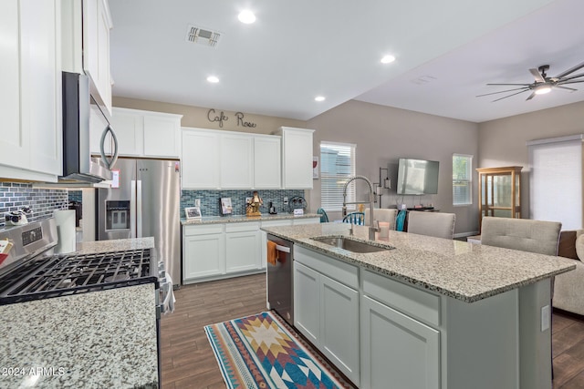 kitchen featuring dark wood-type flooring, white cabinets, sink, an island with sink, and appliances with stainless steel finishes