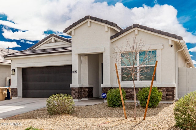 view of front of home featuring stucco siding, an attached garage, stone siding, driveway, and a tiled roof