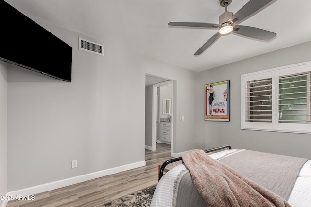 bedroom featuring a baseboard heating unit, ceiling fan, and light wood-type flooring