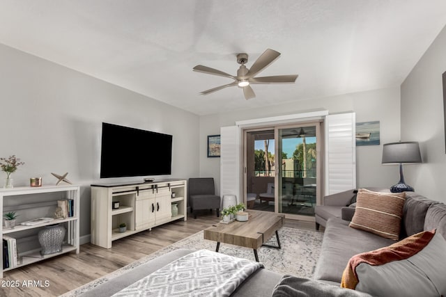 living room featuring ceiling fan and light hardwood / wood-style floors