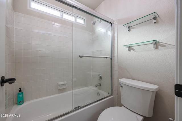 bathroom with toilet and shower / bath combination with glass door