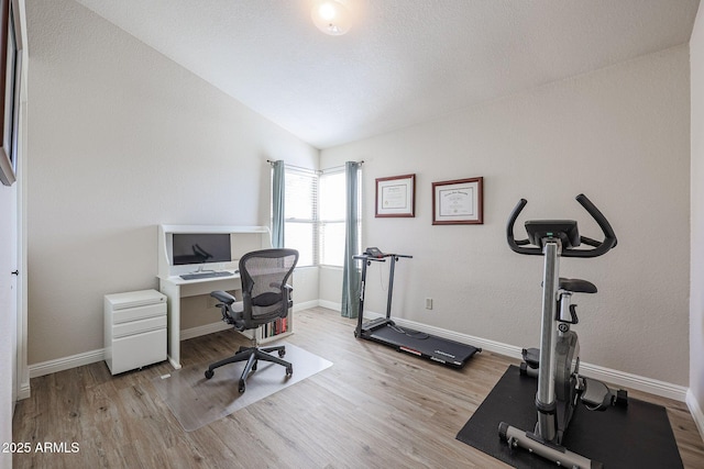 office with lofted ceiling and light hardwood / wood-style floors