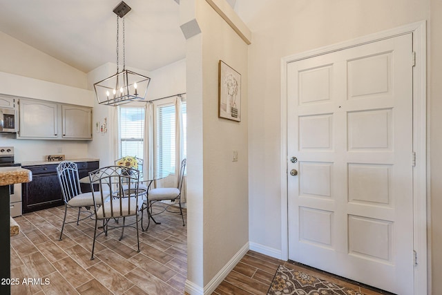 dining area with an inviting chandelier and vaulted ceiling