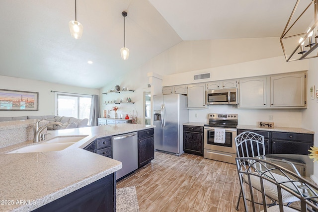 kitchen featuring decorative light fixtures, sink, gray cabinetry, light hardwood / wood-style floors, and stainless steel appliances