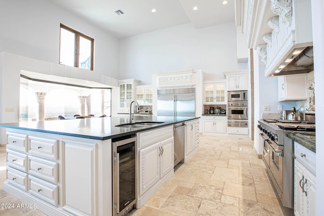 kitchen with white cabinets, wine cooler, and built in appliances