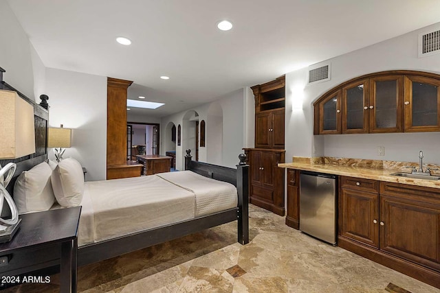 bedroom with stainless steel refrigerator and sink