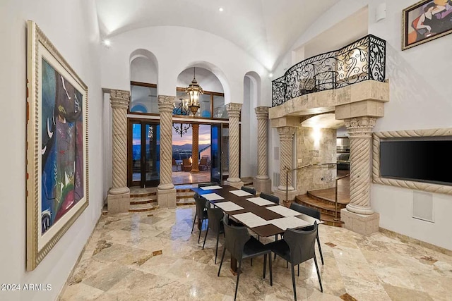 dining area featuring french doors, lofted ceiling, and ornate columns