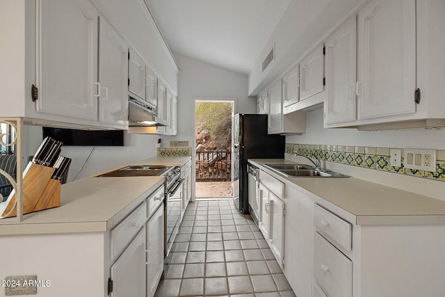 kitchen featuring white cabinets, lofted ceiling, light tile patterned floors, sink, and appliances with stainless steel finishes