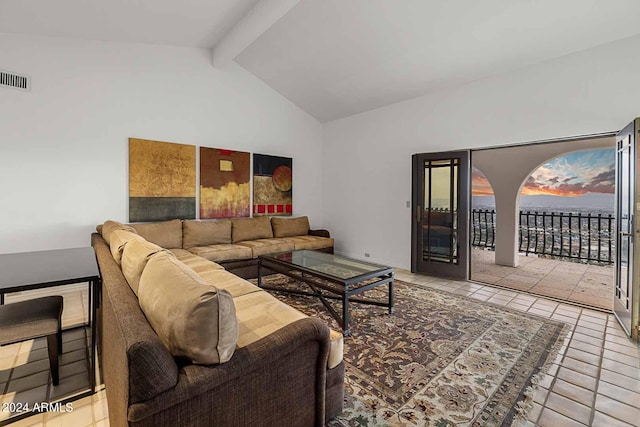 living room featuring lofted ceiling with beams and light tile patterned floors