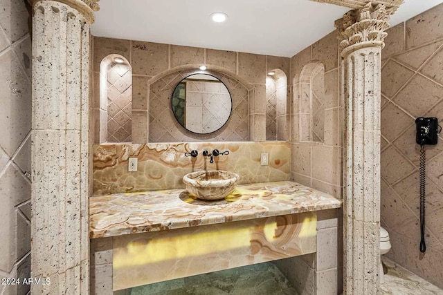 bathroom featuring tile walls, decorative backsplash, vanity, and toilet