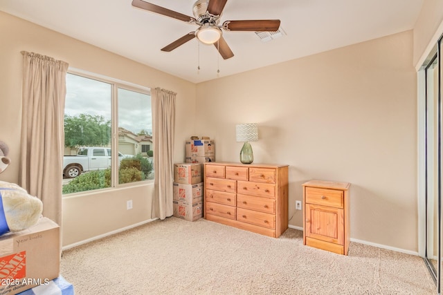 carpeted bedroom featuring multiple windows and ceiling fan