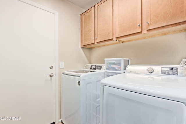 washroom featuring cabinets and washing machine and dryer