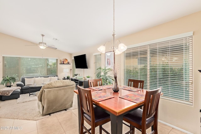 dining space with light tile patterned floors, ceiling fan with notable chandelier, and vaulted ceiling