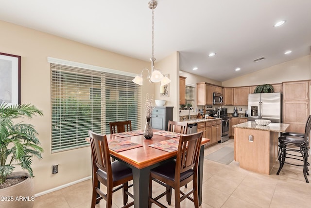 dining room featuring sink, a chandelier, vaulted ceiling, and light tile patterned floors