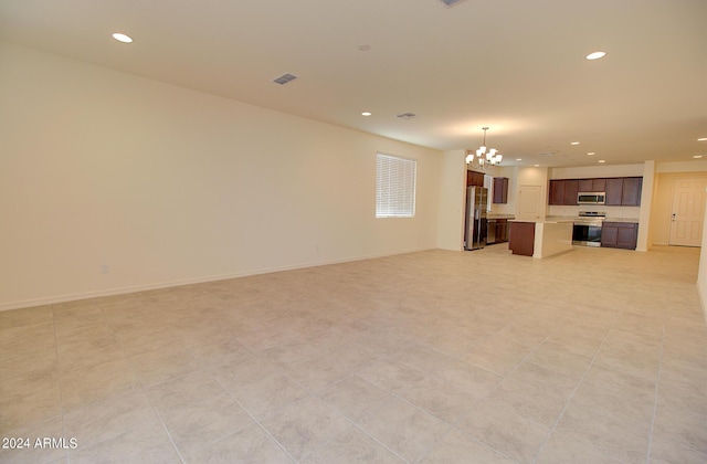 unfurnished living room featuring light tile patterned floors and an inviting chandelier