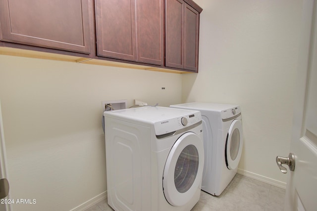 laundry room with cabinets and washing machine and clothes dryer