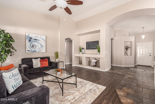 living room featuring ceiling fan, lofted ceiling, and dark hardwood / wood-style flooring